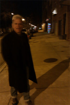 Jim Cory, poet, on night street with long shadow